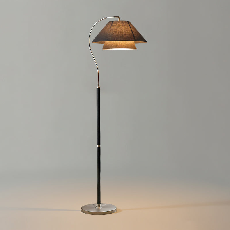 Gulvlampe med varmt lys mot mørk bakvegg